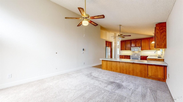 kitchen featuring white appliances, lofted ceiling, kitchen peninsula, and a textured ceiling