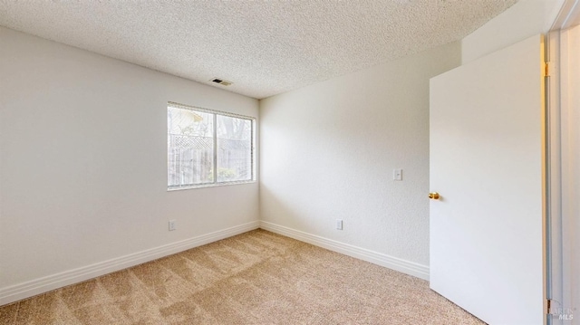 carpeted empty room featuring a textured ceiling