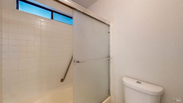 bathroom with toilet and combined bath / shower with glass door