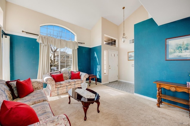 carpeted living area with high vaulted ceiling, visible vents, and baseboards