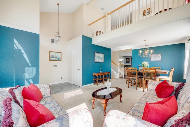 living area featuring carpet floors, visible vents, a towering ceiling, stairway, and baseboards