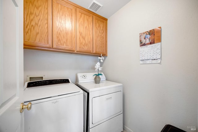 washroom featuring cabinet space, visible vents, and washing machine and clothes dryer