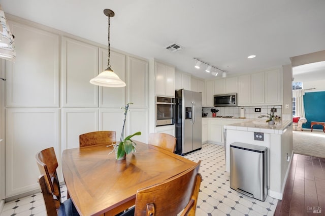 kitchen with tasteful backsplash, visible vents, appliances with stainless steel finishes, light floors, and white cabinetry