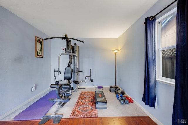 exercise area featuring baseboards and wood finished floors