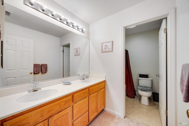 bathroom with baseboards, double vanity, a sink, and tile patterned floors