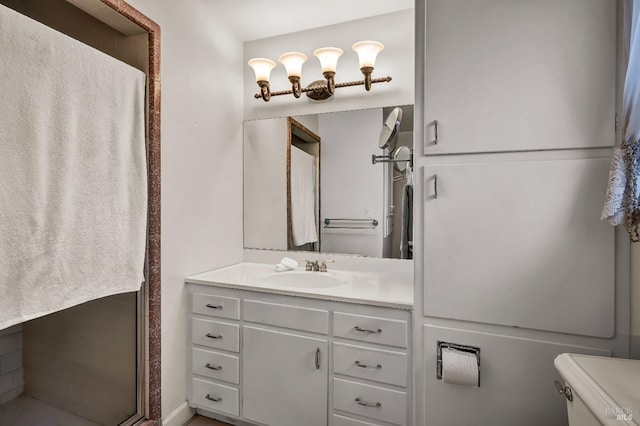 bathroom with vanity, an enclosed shower, and toilet