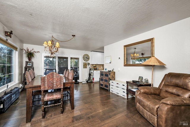 dining space with dark wood-type flooring, a textured ceiling, and a notable chandelier