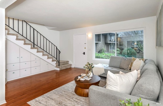 living room with stairs and dark wood finished floors