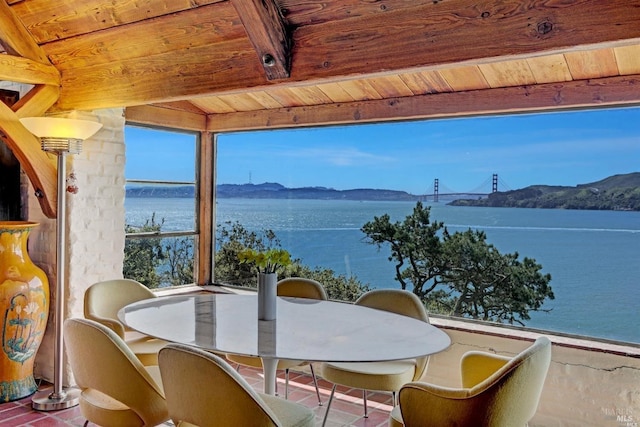 sunroom featuring beam ceiling, a water and mountain view, and wooden ceiling