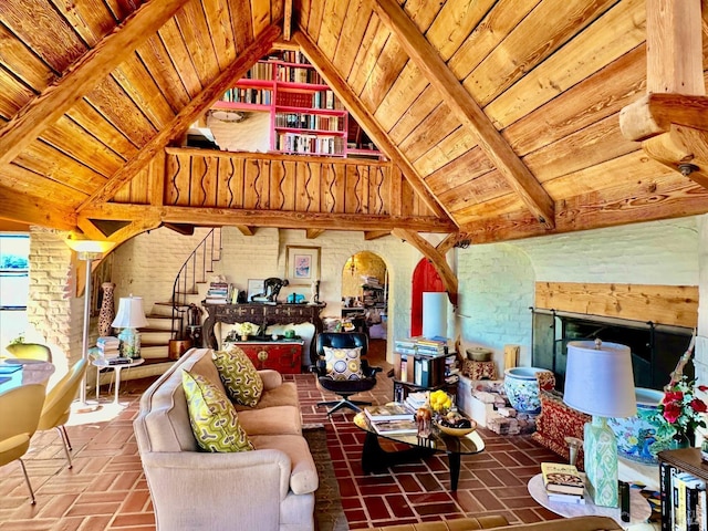 living room featuring beam ceiling, wood ceiling, high vaulted ceiling, and brick wall