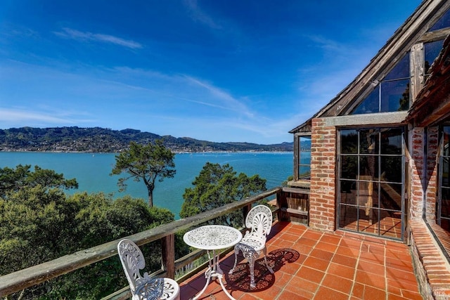 balcony featuring a water and mountain view