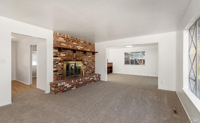 unfurnished living room with carpet flooring, a fireplace, and plenty of natural light