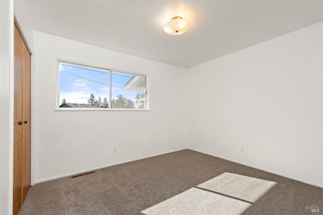 empty room featuring dark colored carpet