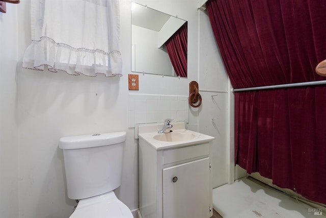 bathroom with vanity, toilet, and backsplash