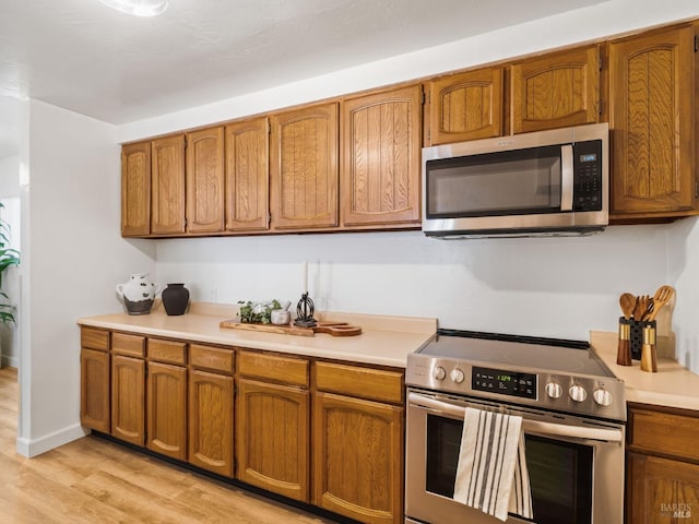 kitchen with stainless steel appliances and light hardwood / wood-style floors