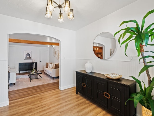 hallway featuring a notable chandelier and light hardwood / wood-style flooring