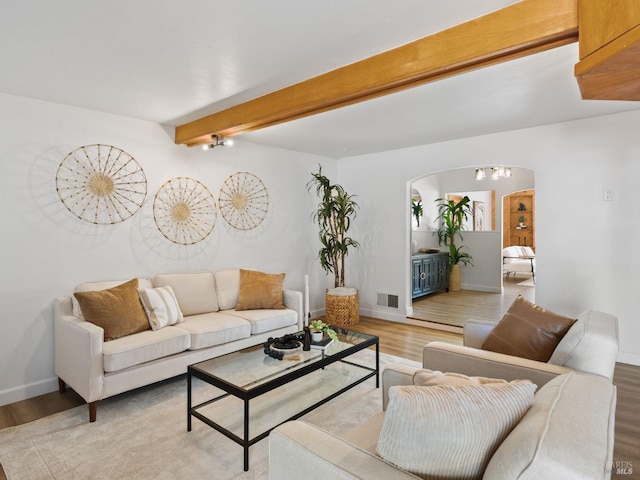 living room featuring beamed ceiling and hardwood / wood-style floors