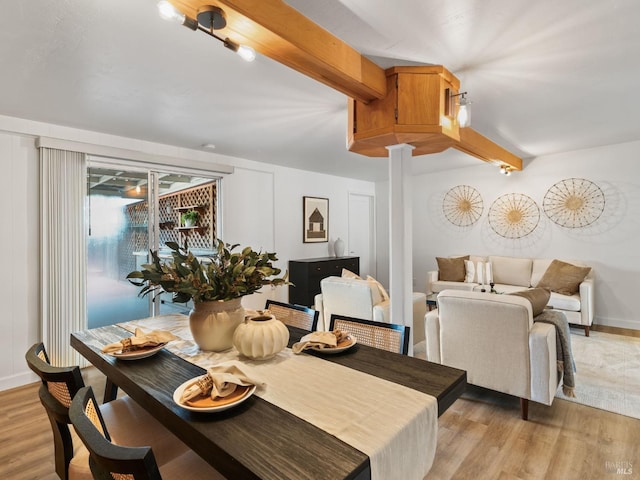 dining room featuring light hardwood / wood-style flooring, decorative columns, and beamed ceiling