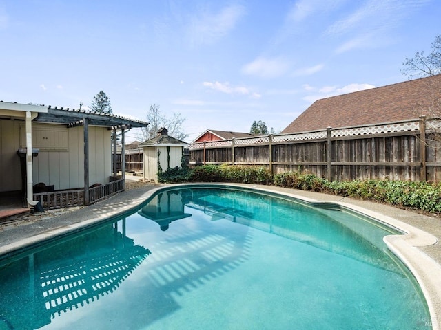 view of swimming pool featuring an outbuilding and a pergola