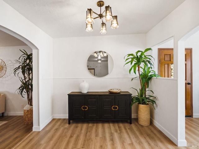 hall with an inviting chandelier and light hardwood / wood-style flooring