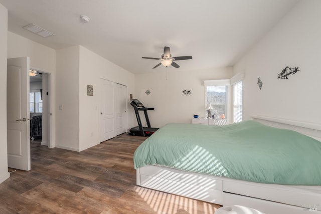 bedroom featuring dark wood-type flooring, ceiling fan, and a closet