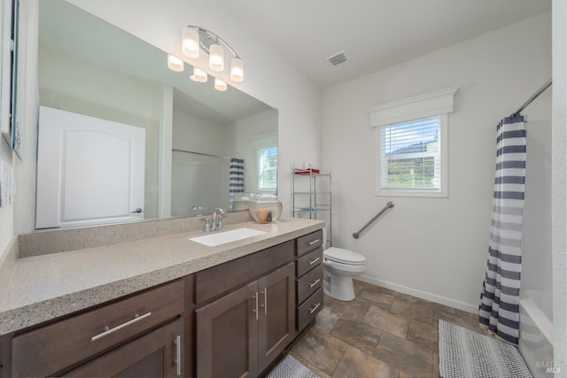 full bathroom featuring vanity, shower / bath combination with curtain, toilet, and a healthy amount of sunlight