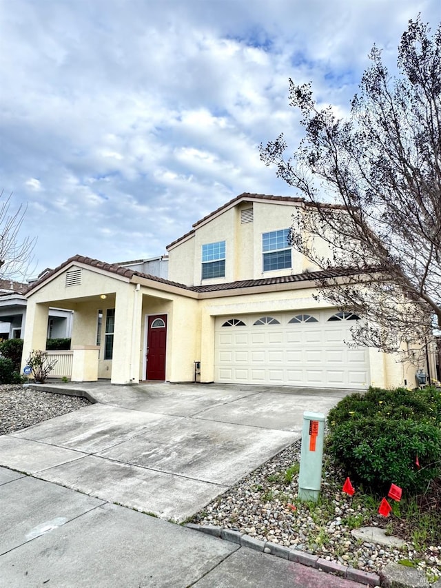 view of front facade featuring a tiled roof, concrete driveway, and stucco siding