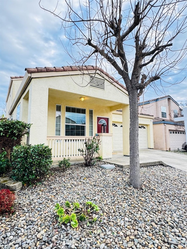 view of front of property featuring driveway, a tiled roof, and stucco siding