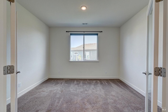 spare room featuring light carpet