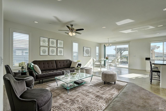 tiled living room featuring ceiling fan with notable chandelier