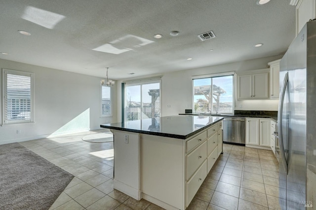 kitchen featuring white cabinetry, a healthy amount of sunlight, appliances with stainless steel finishes, and a center island