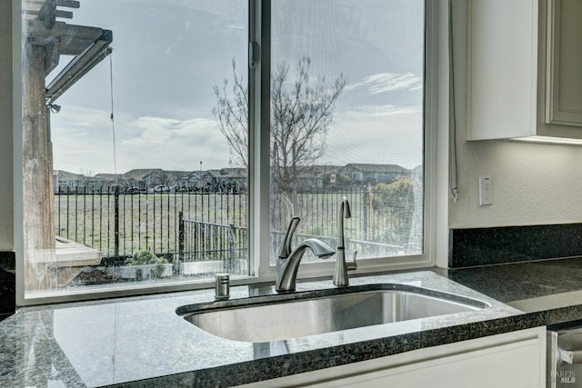 kitchen featuring white cabinetry and sink