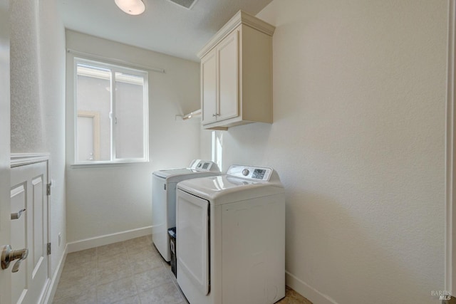 laundry room with cabinets, light tile patterned flooring, and washer and dryer