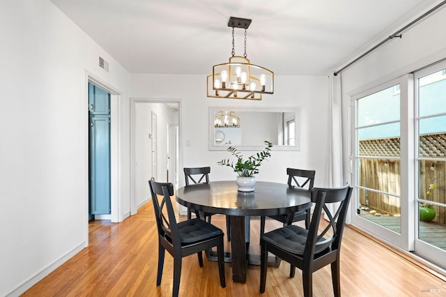 dining room featuring light hardwood / wood-style flooring and a notable chandelier