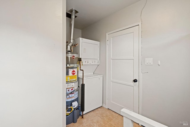 laundry room featuring stacked washer / drying machine, light tile patterned floors, and water heater