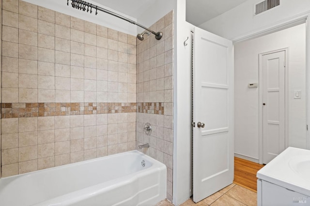 bathroom featuring tiled shower / bath, tile patterned floors, and vanity