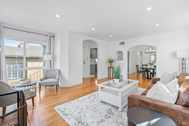 living room featuring a chandelier and light wood-type flooring