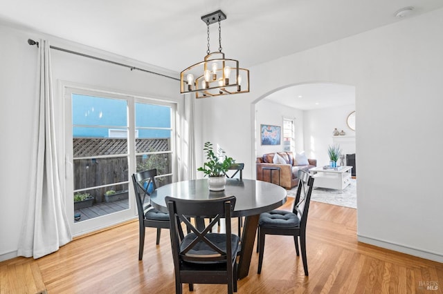 dining area featuring a notable chandelier, light hardwood / wood-style floors, and a wealth of natural light