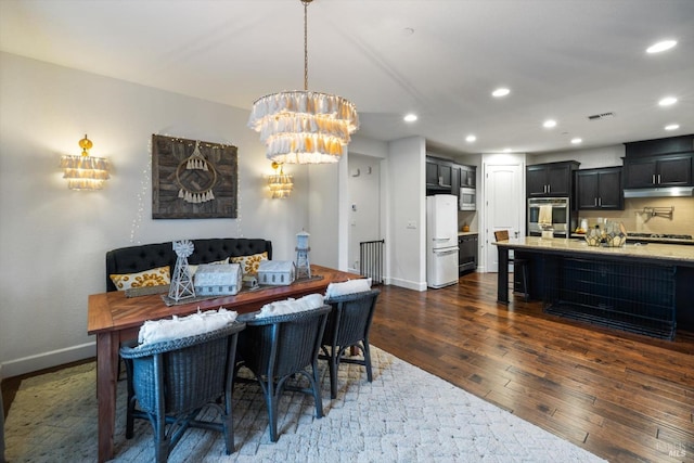 dining room with dark hardwood / wood-style flooring and a chandelier