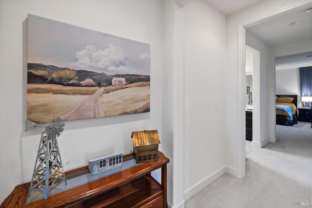 hall featuring light colored carpet