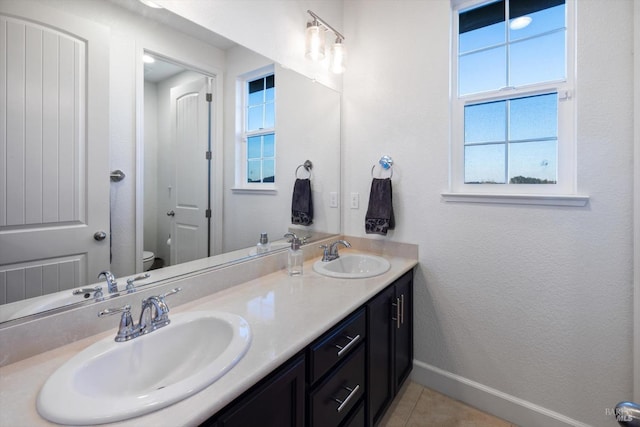 bathroom featuring vanity, tile patterned floors, and toilet