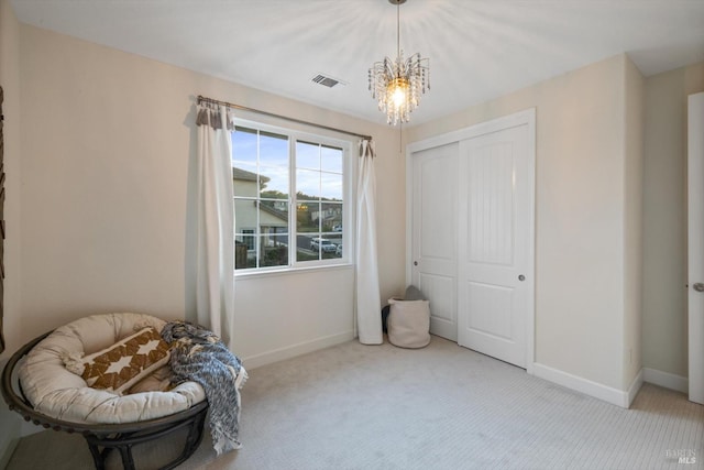 sitting room with light colored carpet and a chandelier