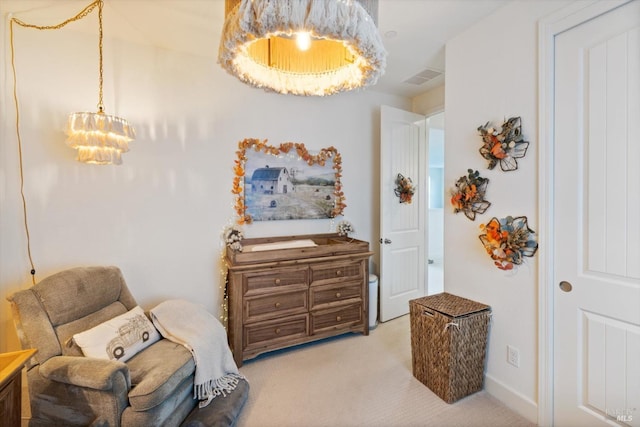 sitting room featuring light colored carpet and a chandelier