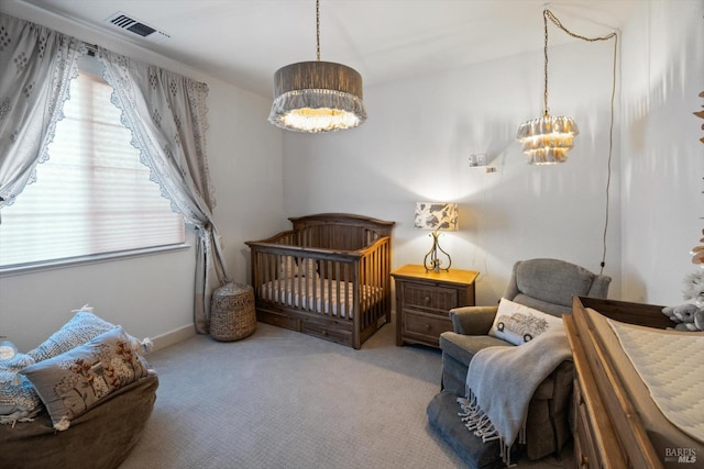 carpeted bedroom with a chandelier and a crib