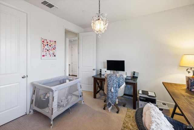 carpeted home office featuring a notable chandelier