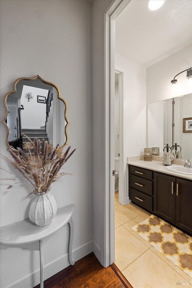 bathroom featuring vanity, tile patterned flooring, and toilet