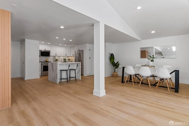 interior space featuring light wood-type flooring, baseboards, and recessed lighting