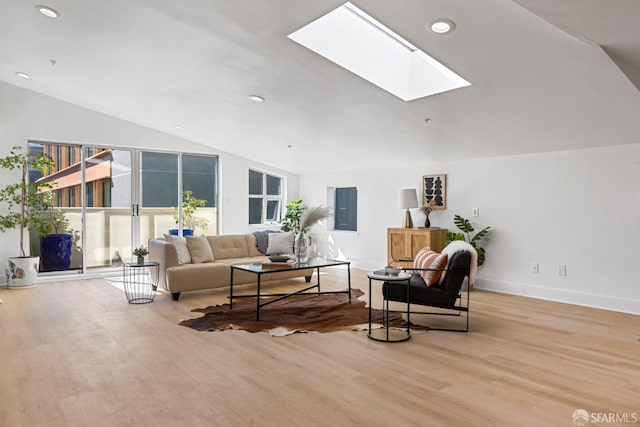 living area with baseboards, lofted ceiling with skylight, wood finished floors, and recessed lighting