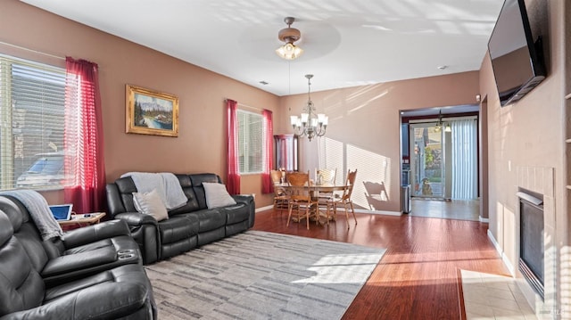 living room featuring an inviting chandelier, a fireplace, and light wood-type flooring