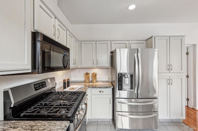 kitchen featuring white cabinetry, appliances with stainless steel finishes, and light stone counters